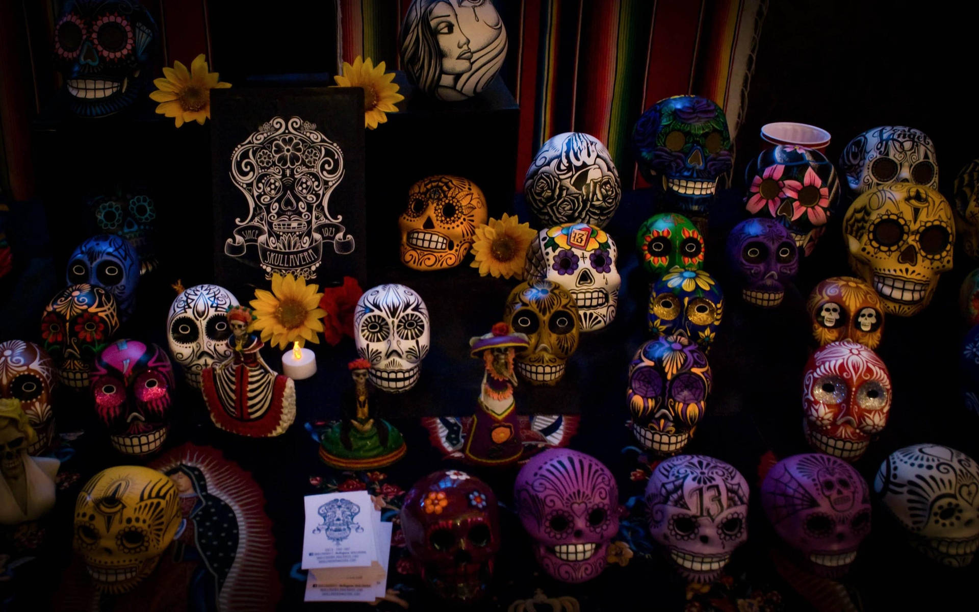 Celebrating Dia De Los Muertos: Vibrantly Adorned Laughing Skulls Background