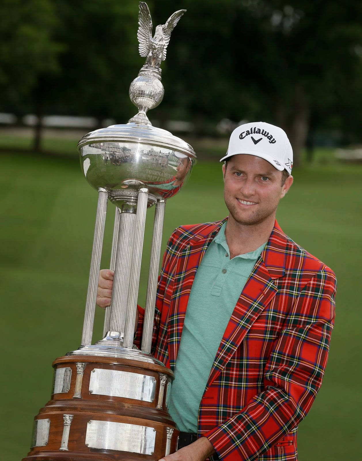 Champion Golfer Chris Kirk Holding A Huge Trophy Background