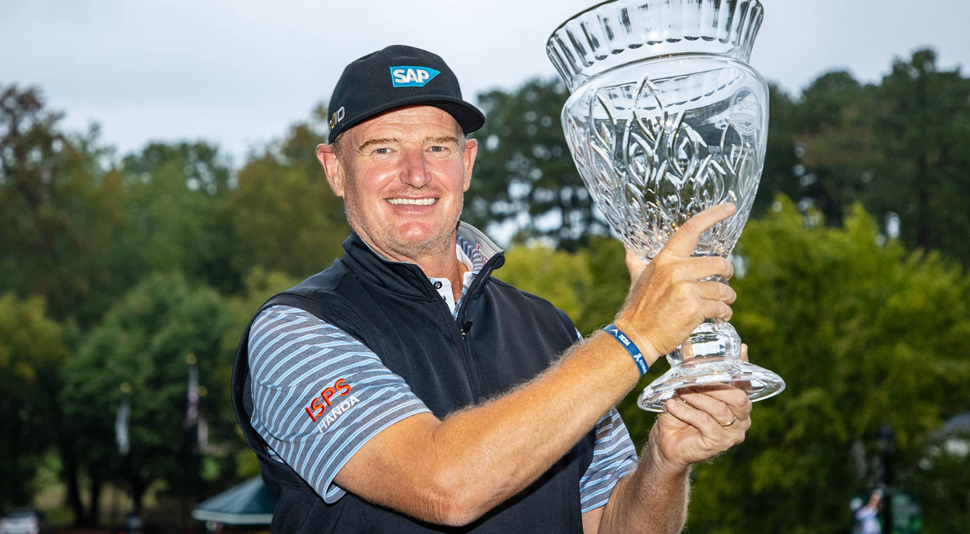 Champion Golfer Ernie Els Holding A Glass Trophy Background