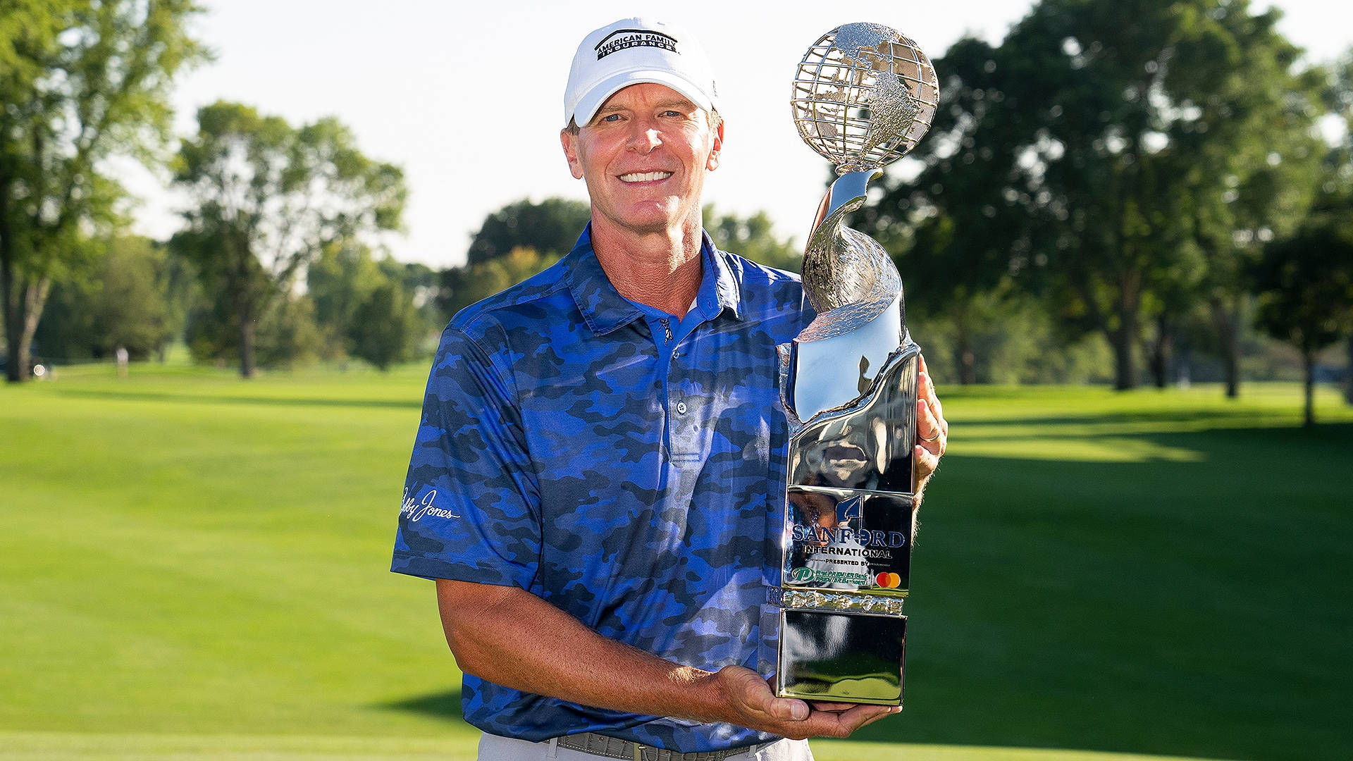 Champion Golfer Steve Stricker Holding Trophy Triumphantly Background