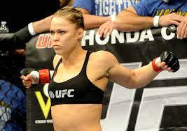 Champion In Action – Ronda Rousey In Fighting Pose Background