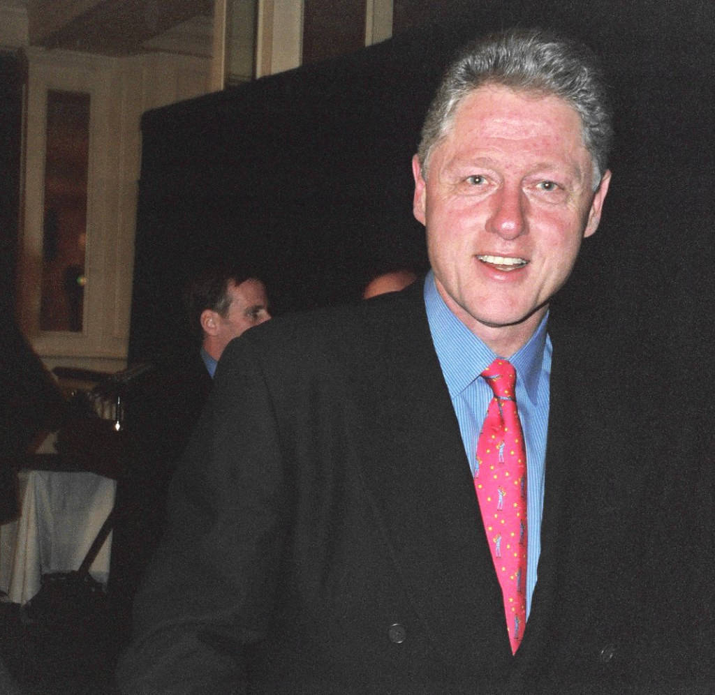 Charismatic Bill Clinton In Sharp Black Suit Background