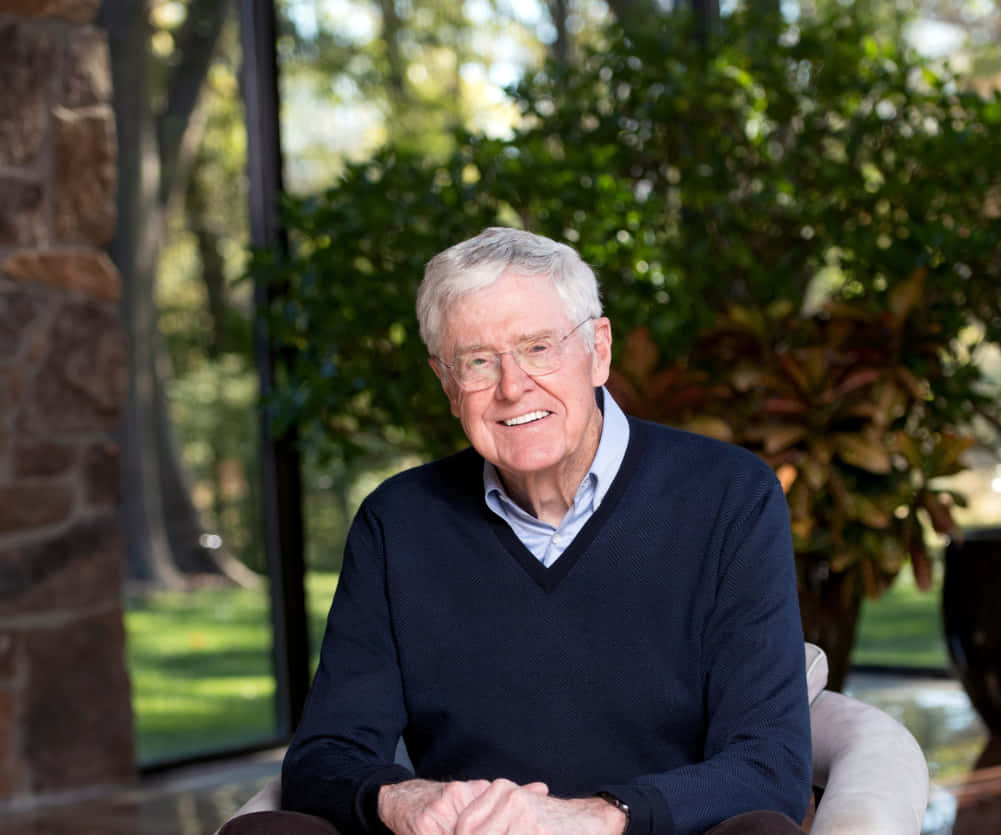 Charles G. Koch Sitting Near Trees Background