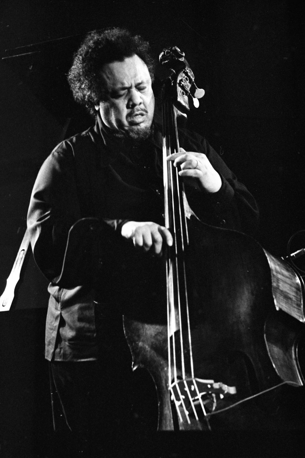 Charles Mingus Soulfully Playing Bass Guitar Background