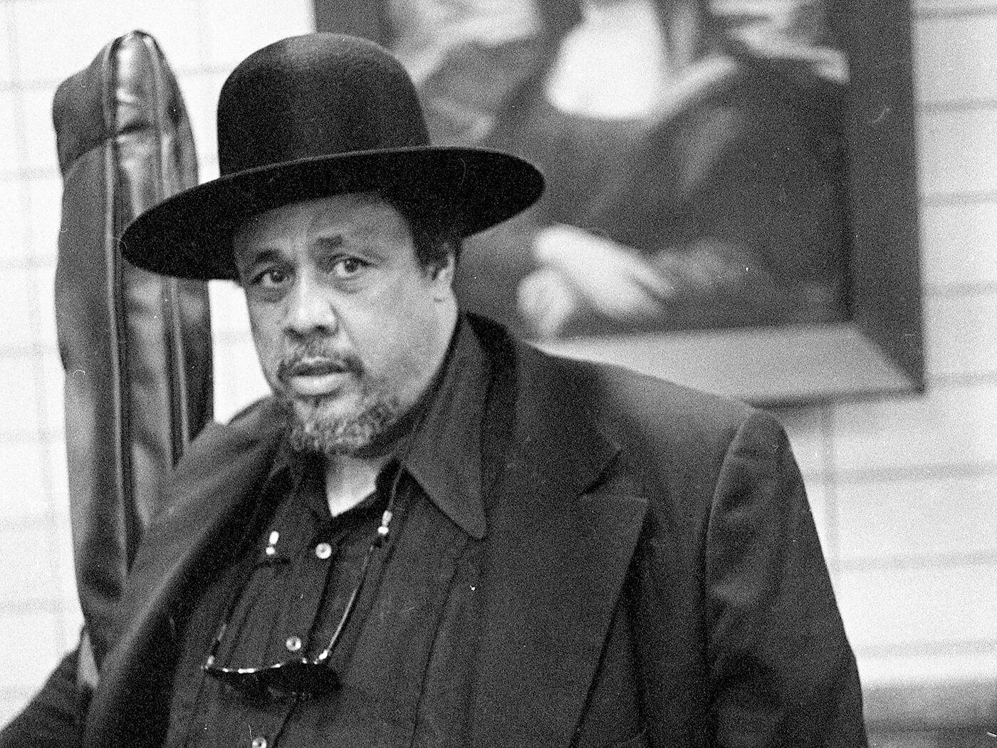 Charles Mingus Wearing Priest Hat And Suit Background