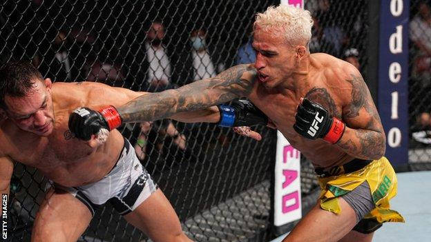 Charles Oliveira In His Triumping Moment, Raising His Arms Inside The Octagon. Background