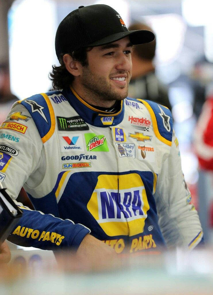 Chase Elliott Triumphantly Standing Before A Blurry Crowd