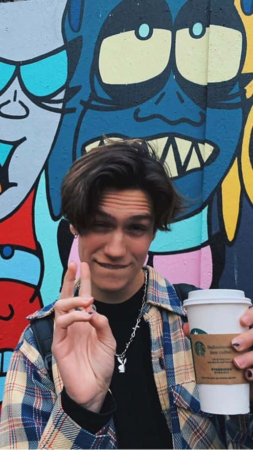 Chase Hudson Dressed In His Iconic Pink Hoodie Background