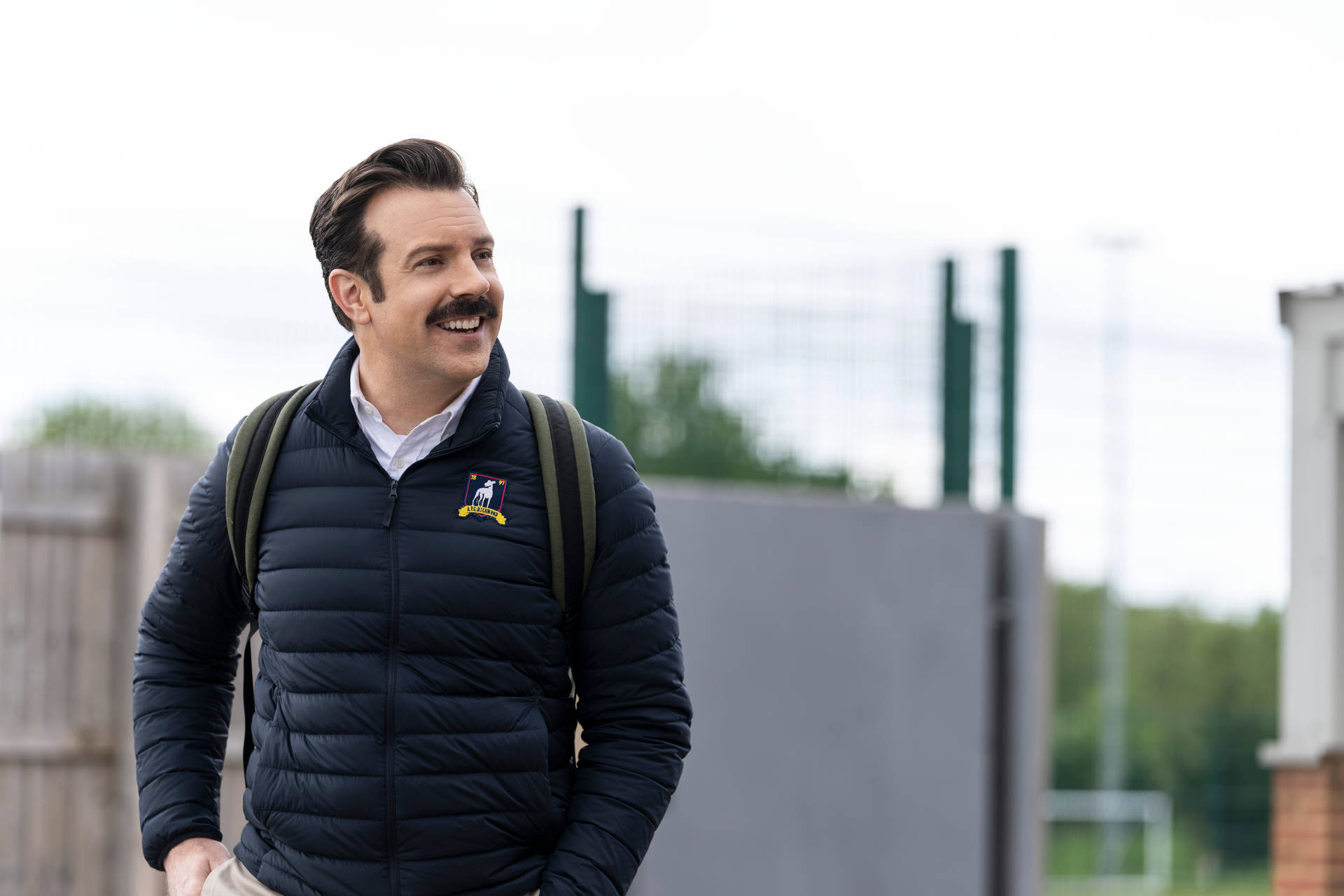 Cheerful Ted Lasso Wearing Jacket Background