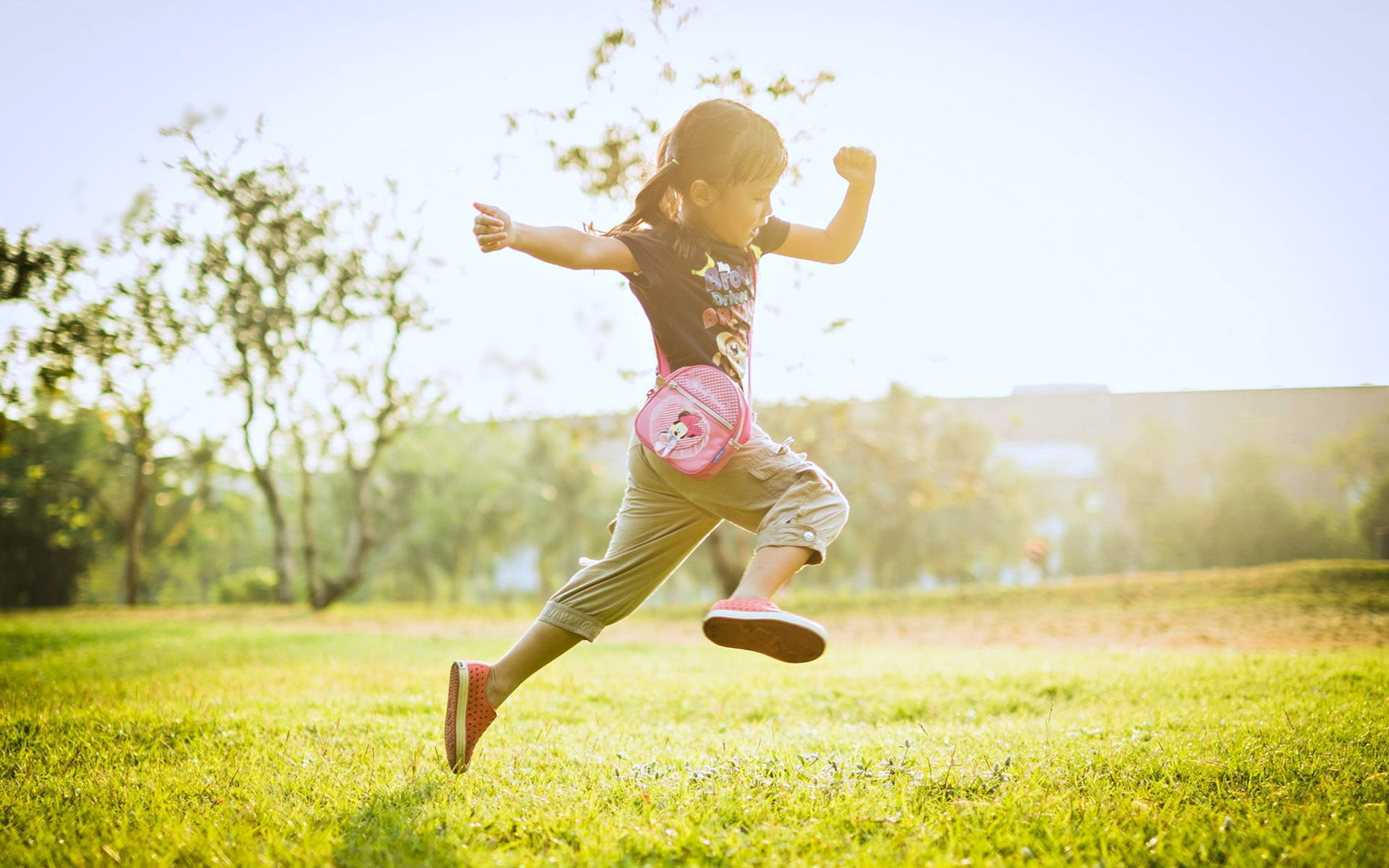 Child Jumping On The Grass Field Background