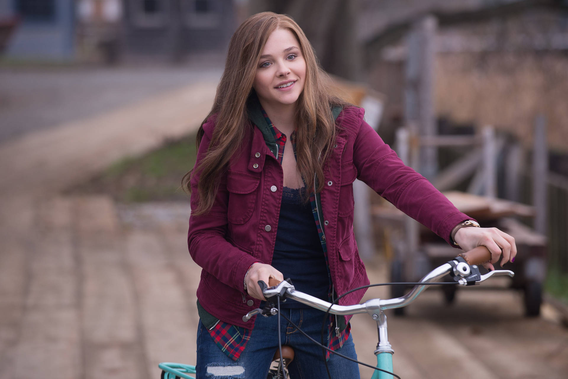Chloë Grace Moretz Riding A Bike Background