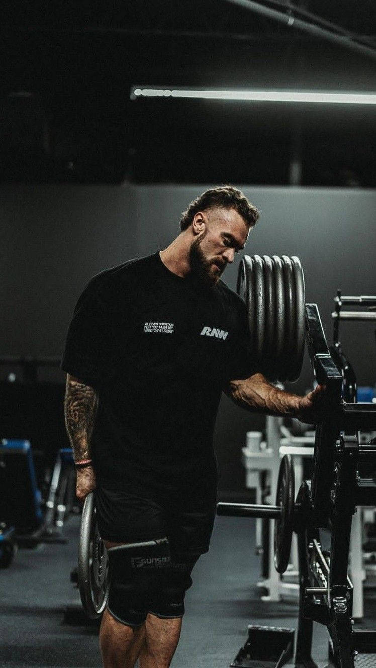 Chris Bumstead Holding A Weight Background