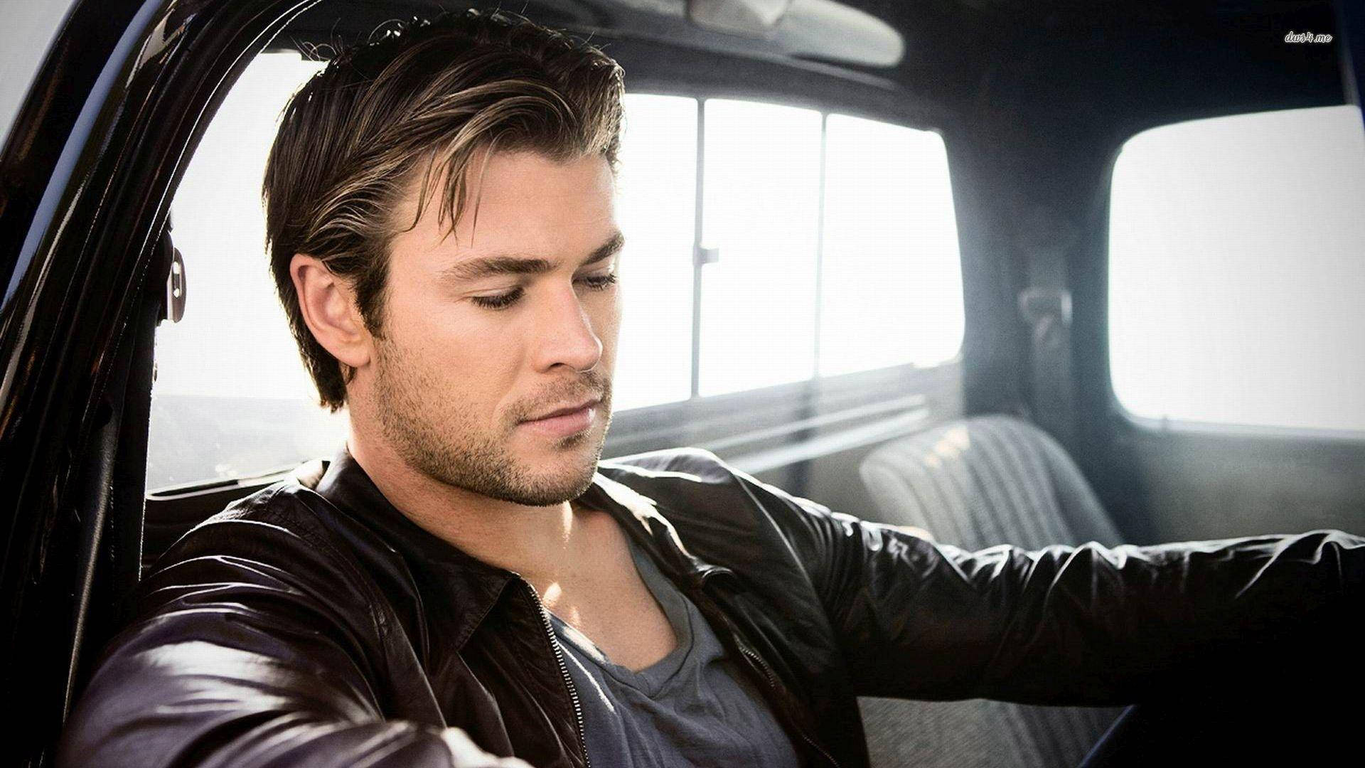 Chris Hemsworth Driving In A Luxurious Car Background