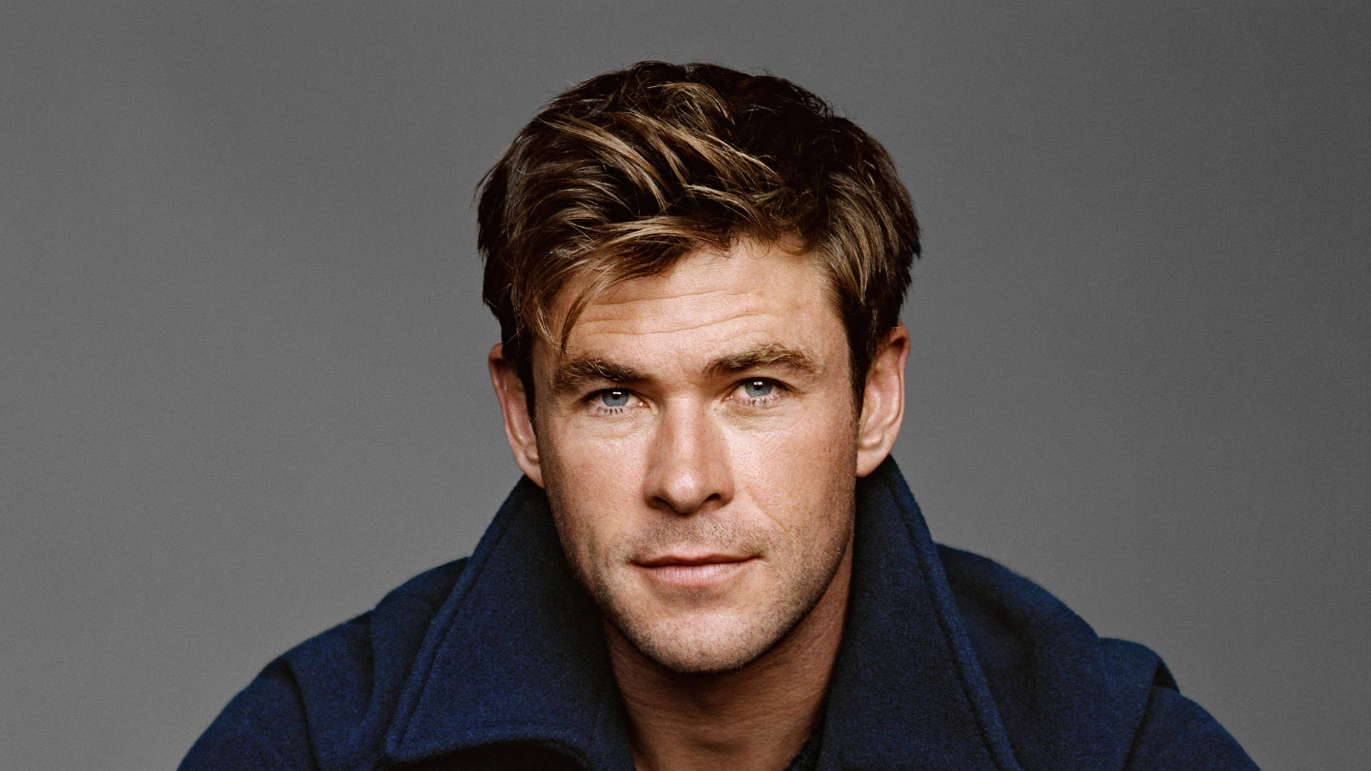 Chris Hemsworth Strikes A Pose In A Blue Jacket. Background