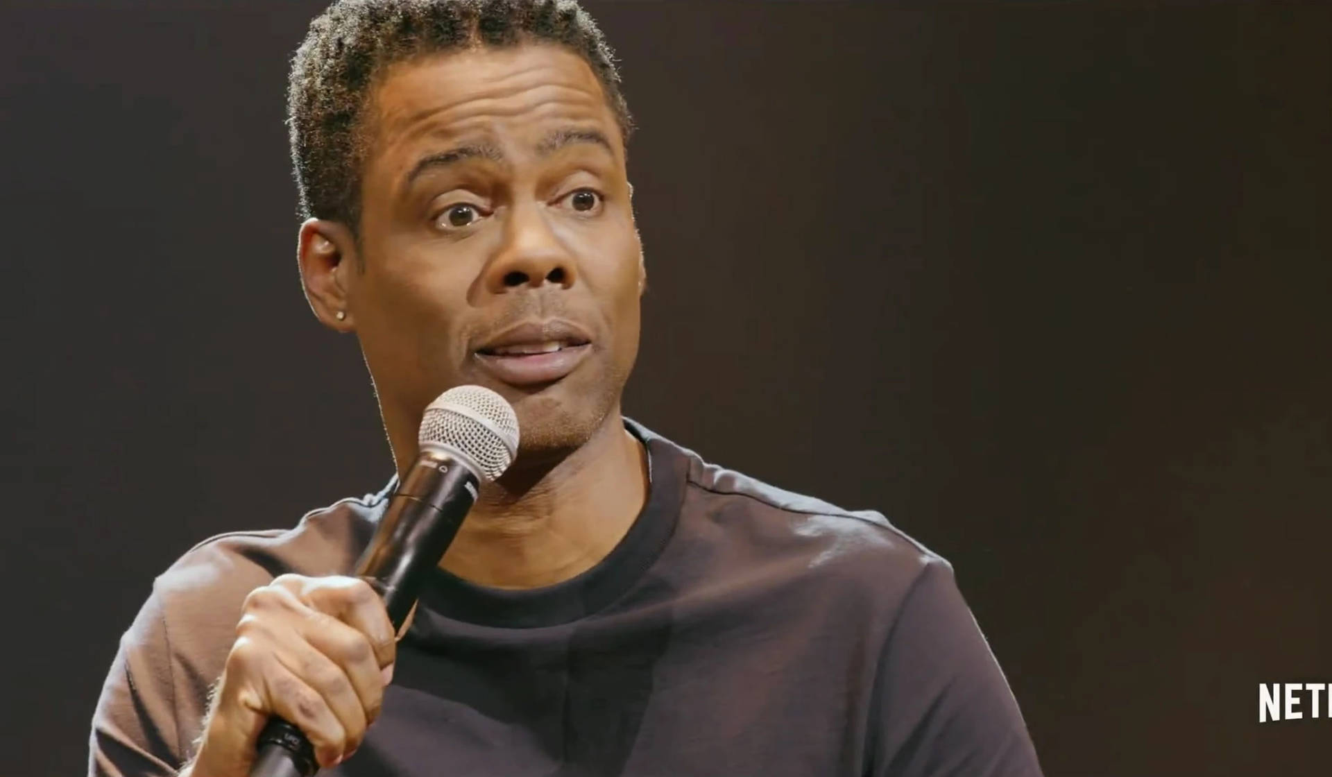 Chris Rock Delivering Dynamic Comedy Performance Background