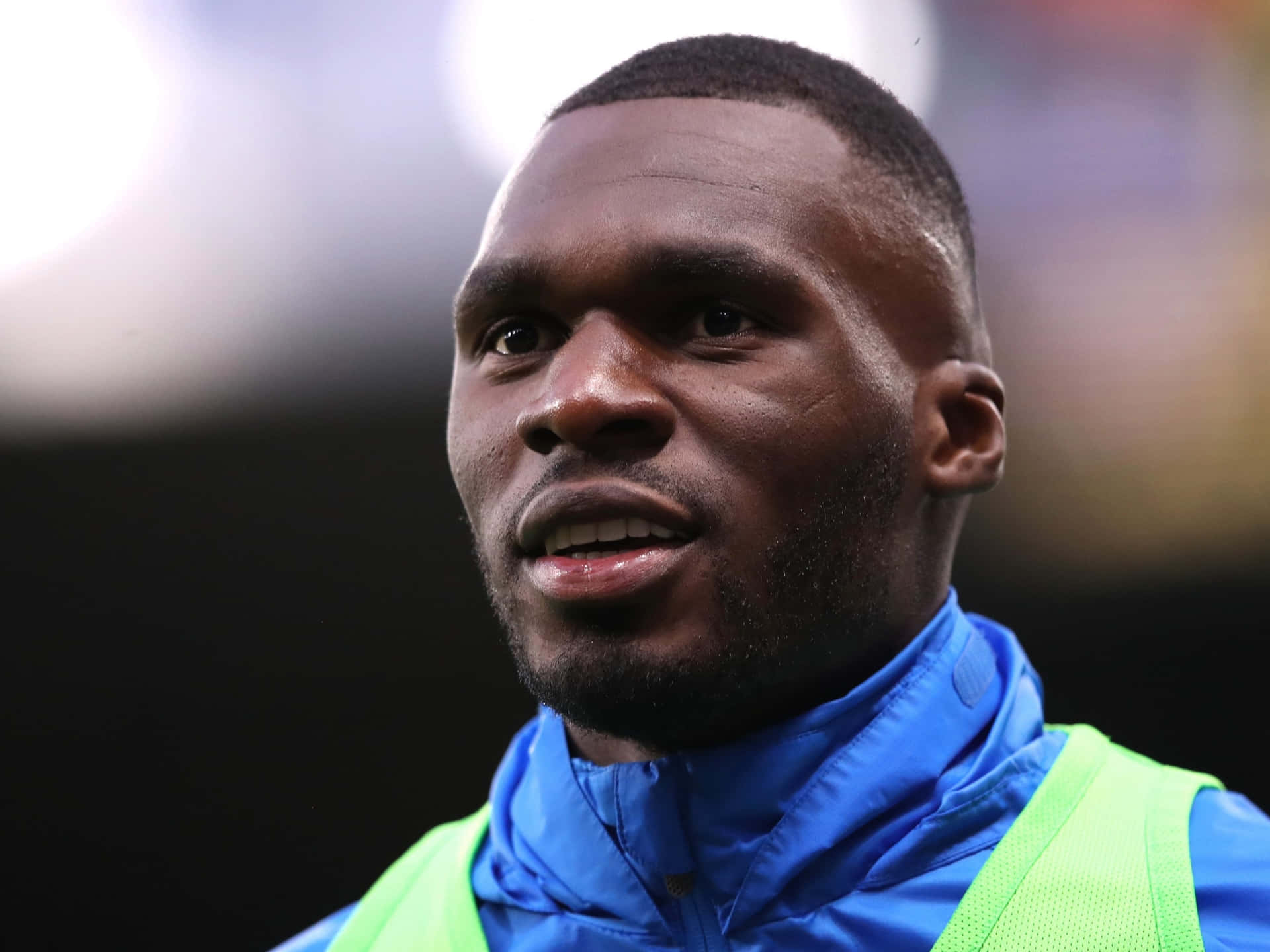 Christian Benteke Wearing Blue Raincoat Background