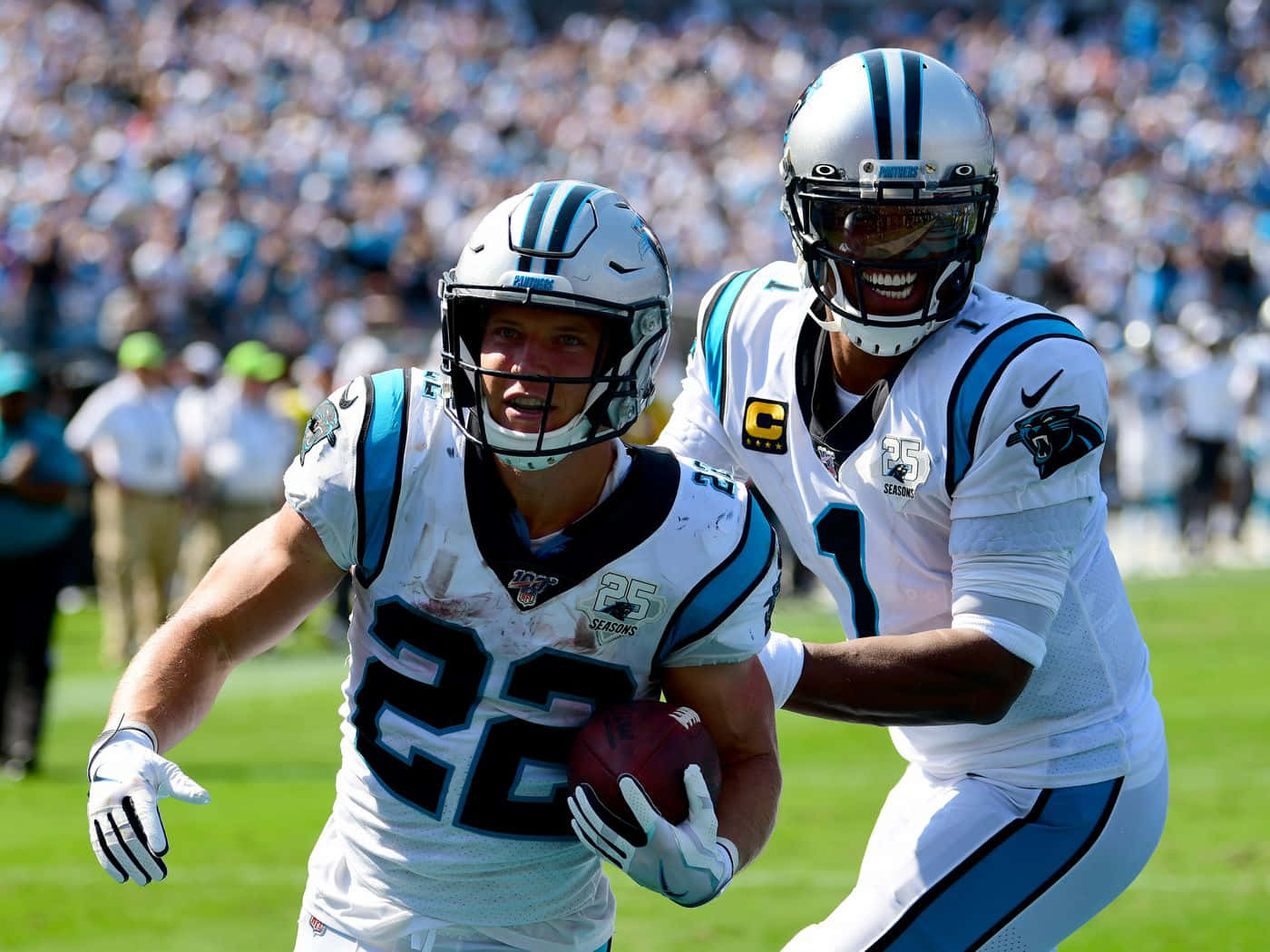 Christian Mccaffrey Surrounded By Carolina Panthers Cheerleaders Background