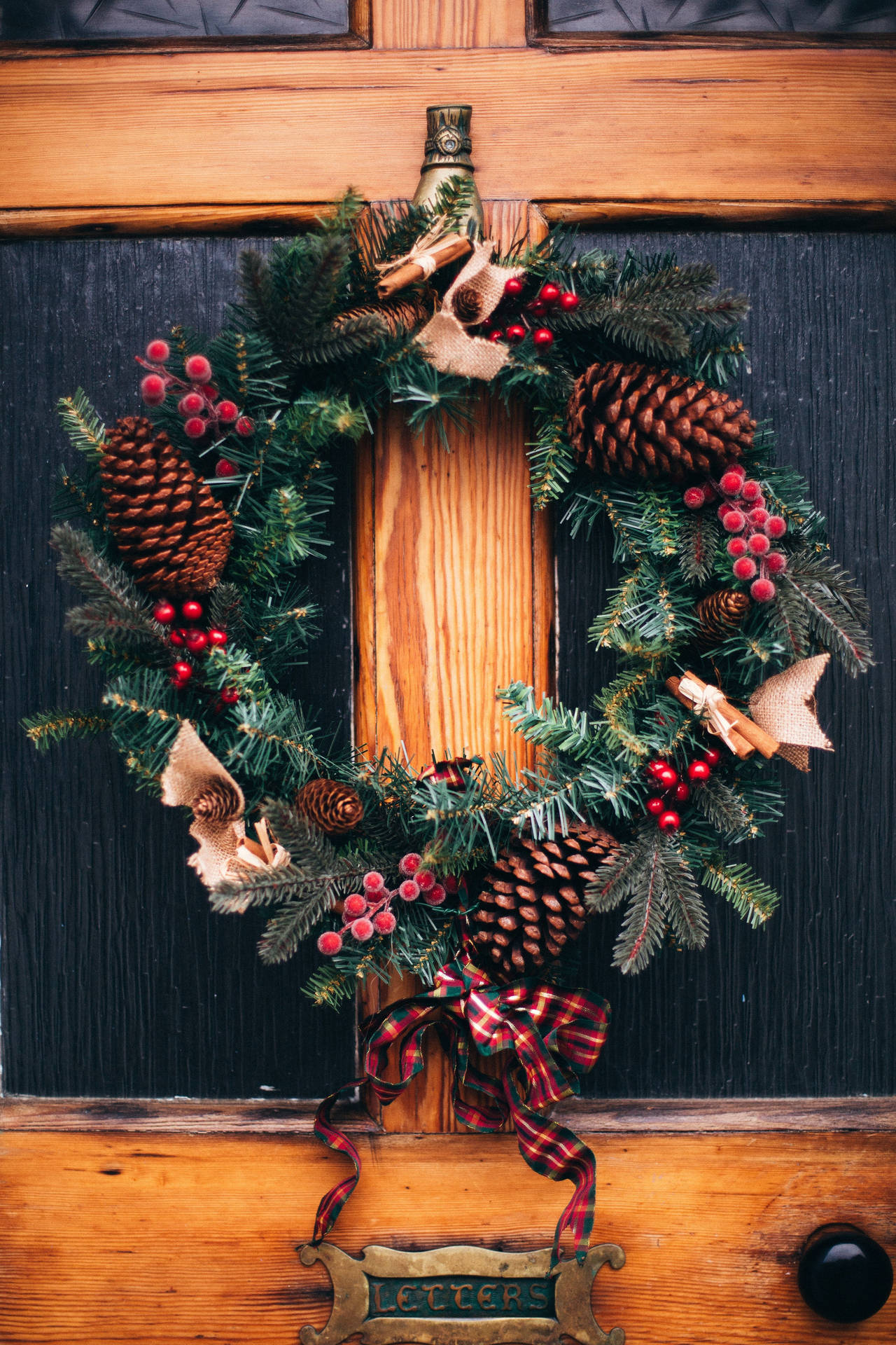Christmas Wreath Embellished With Pinecones And Berries Background