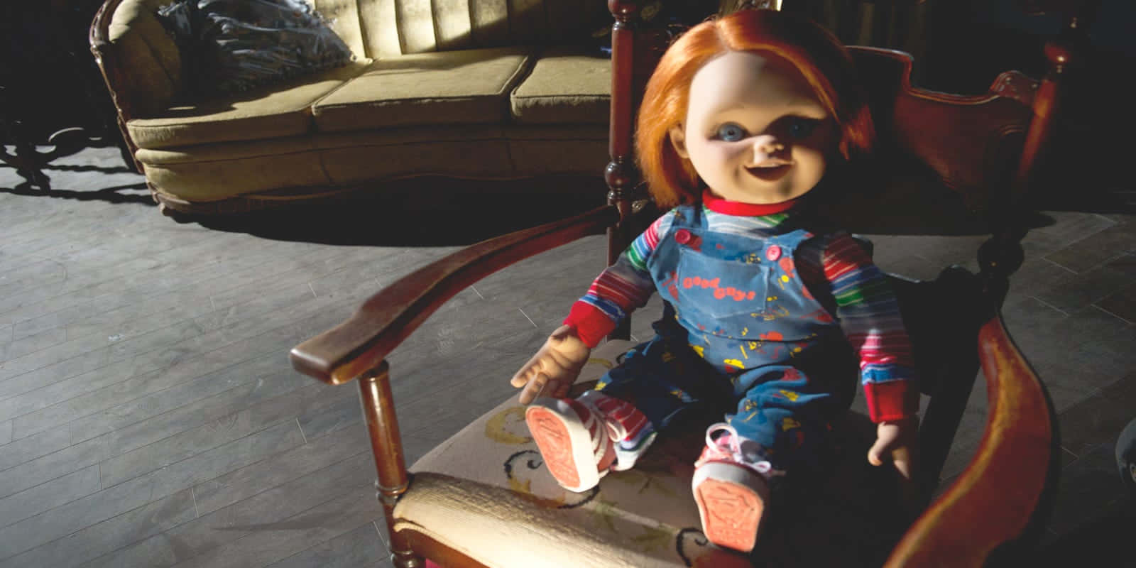 Chucky Doll Sitting On A Chair Background