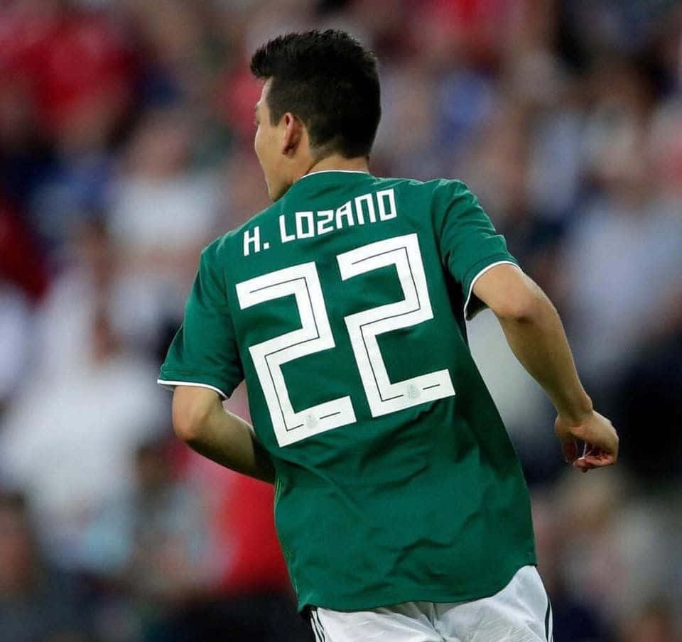 Chucky Lozano Dribbling On The Soccer Pitch Background