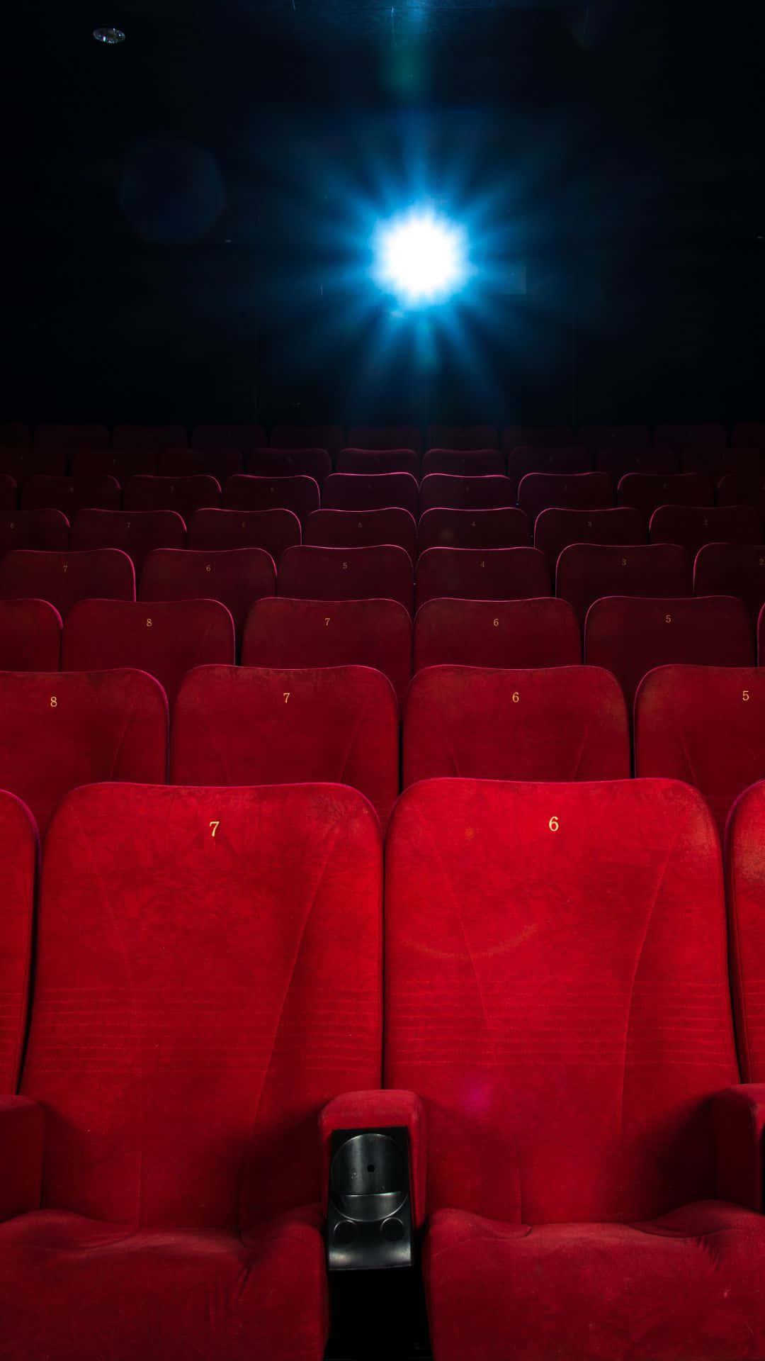 Cinema Hall Empty Seats Under Spotlight Background