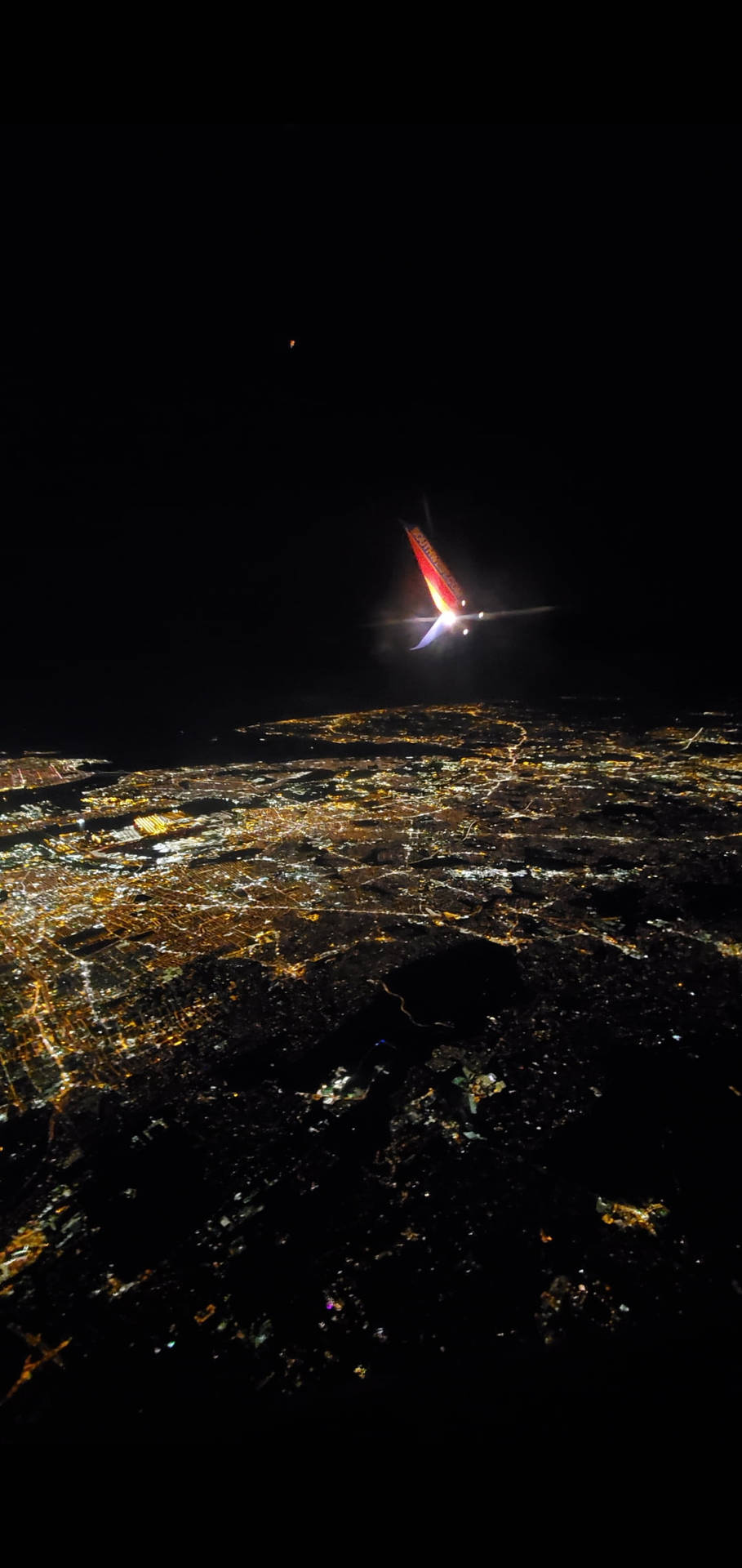 City's Night Scene Viewed From A Plane Window Background