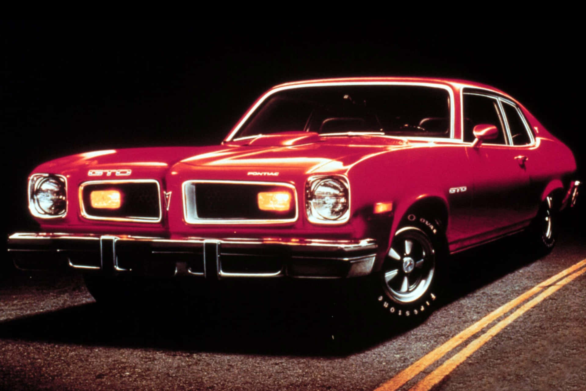 Classic Pontiac Gto Against A Bright Red Sunset Background