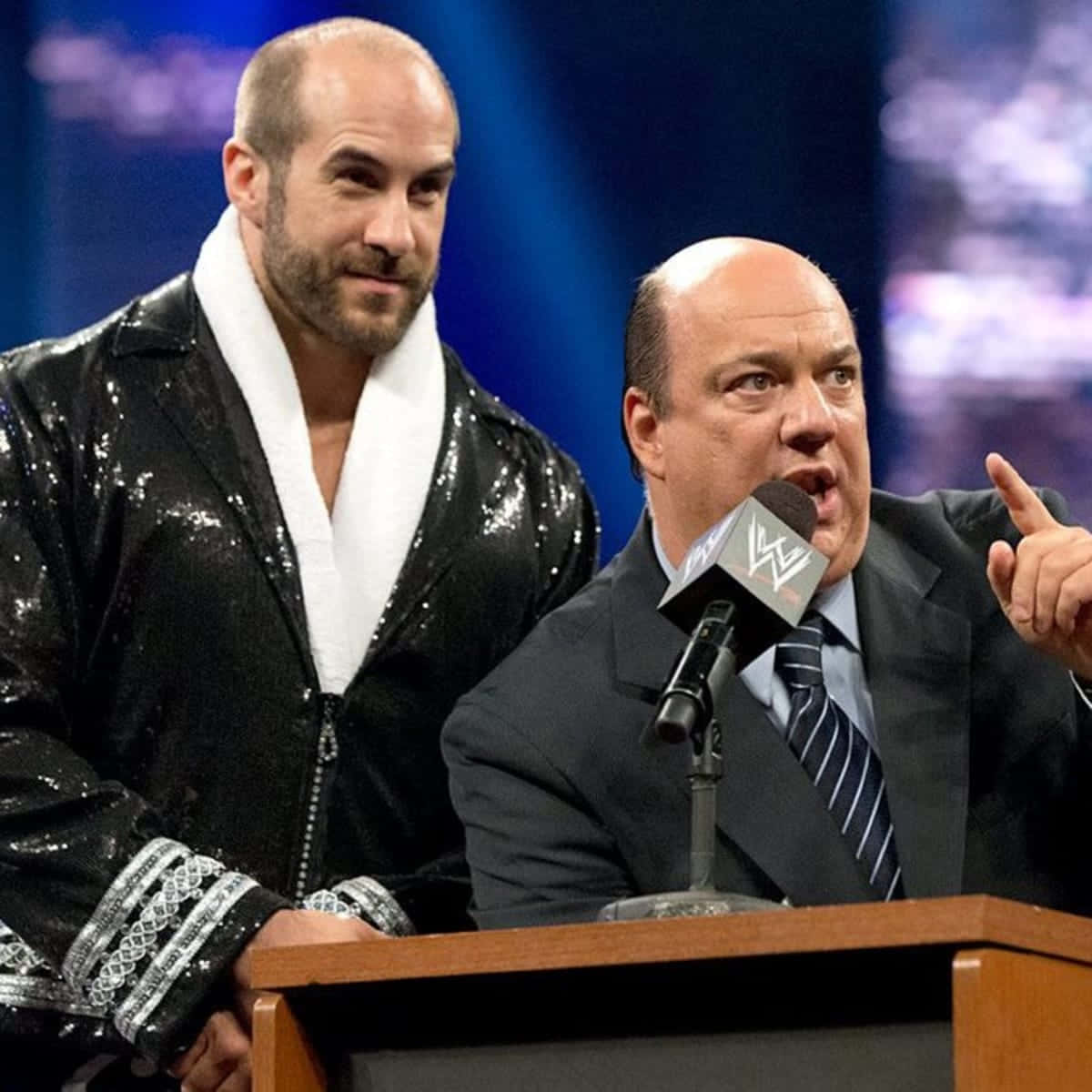 Claudio Castagnoli In Shiny Robe With Paul Heyman Background