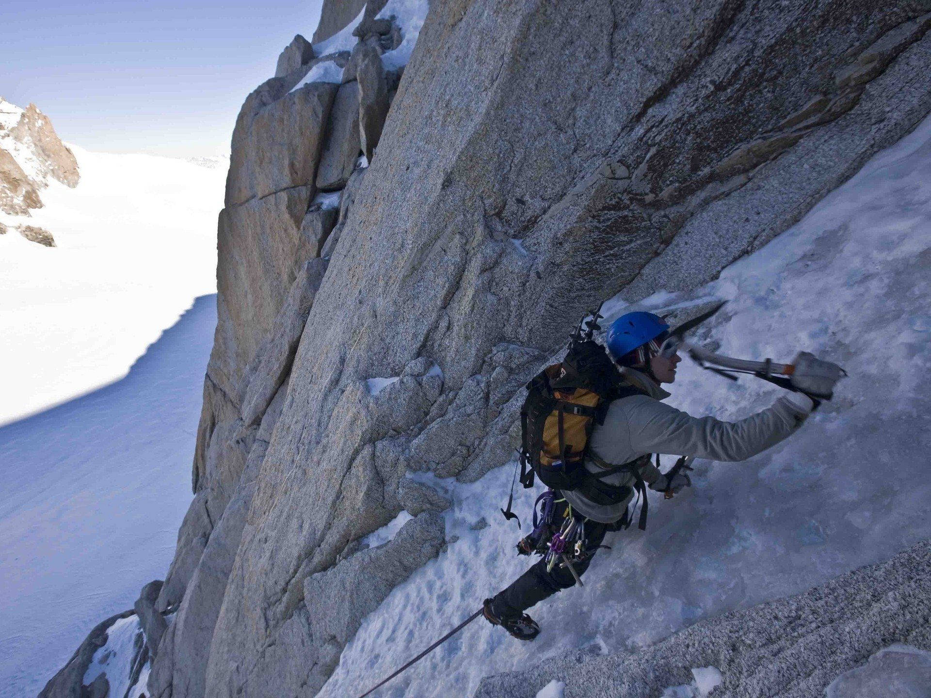 Climbing Mountaineer With Blue Helmet Background
