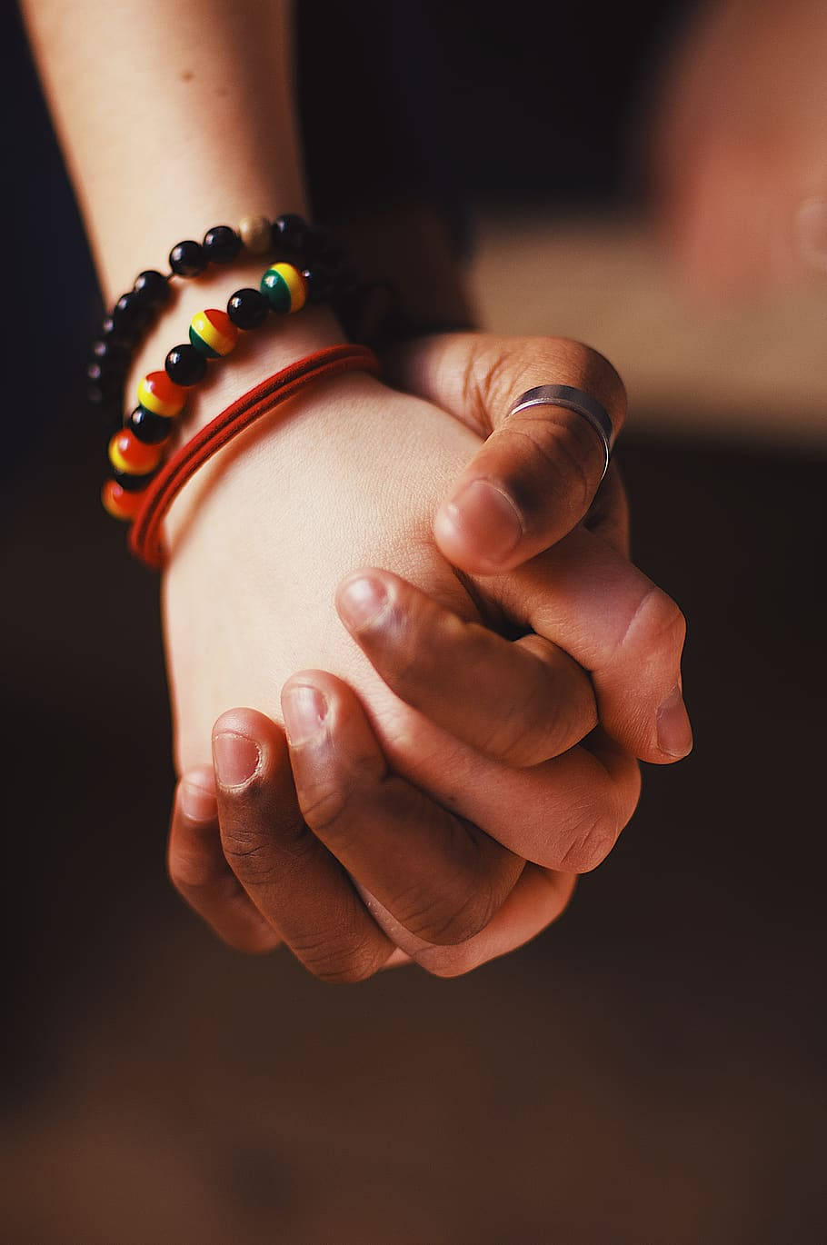 Close Up Holding Hands With Bracelets Background
