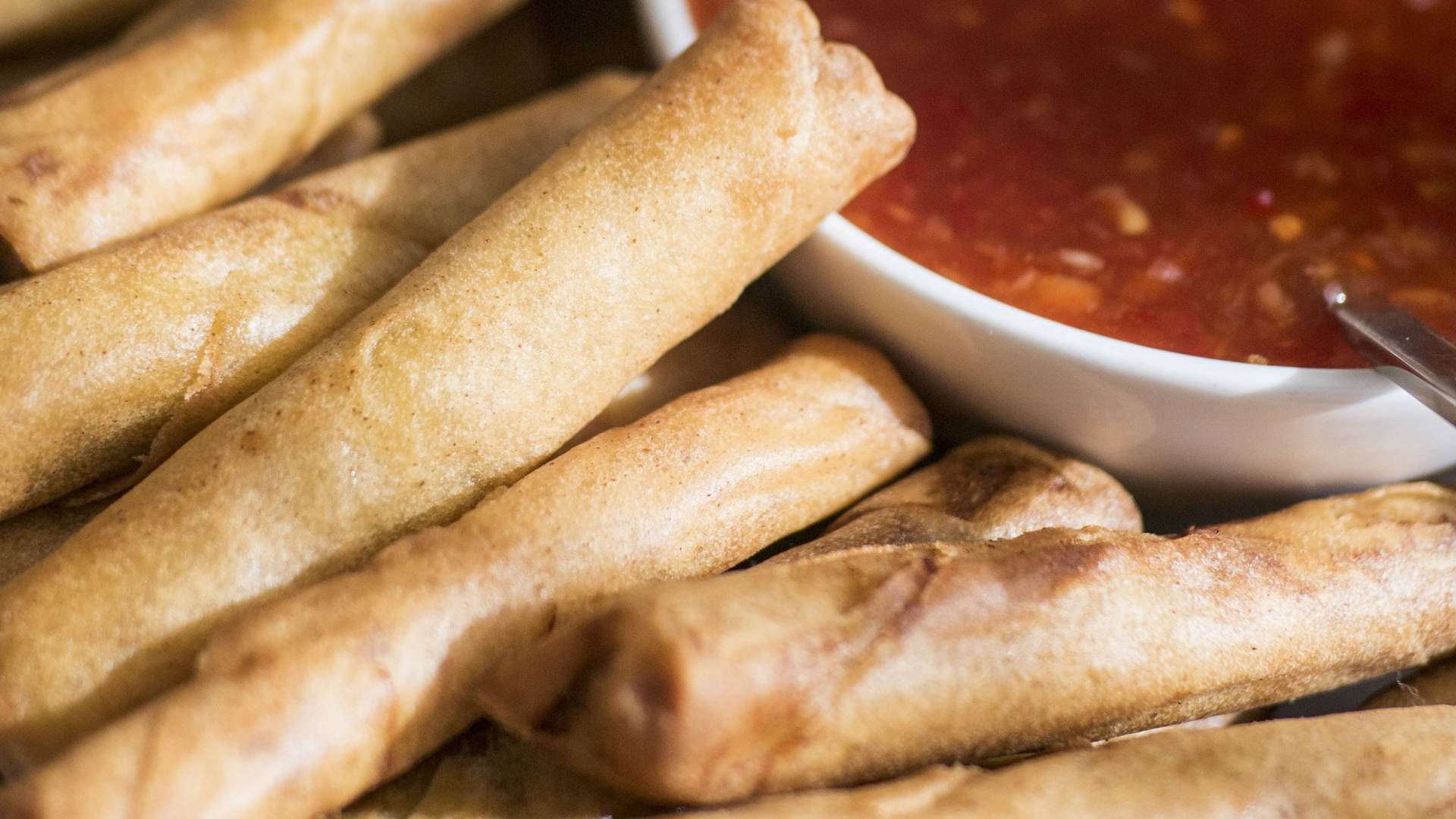 Close-up Of Egg Rolls With Dip Background