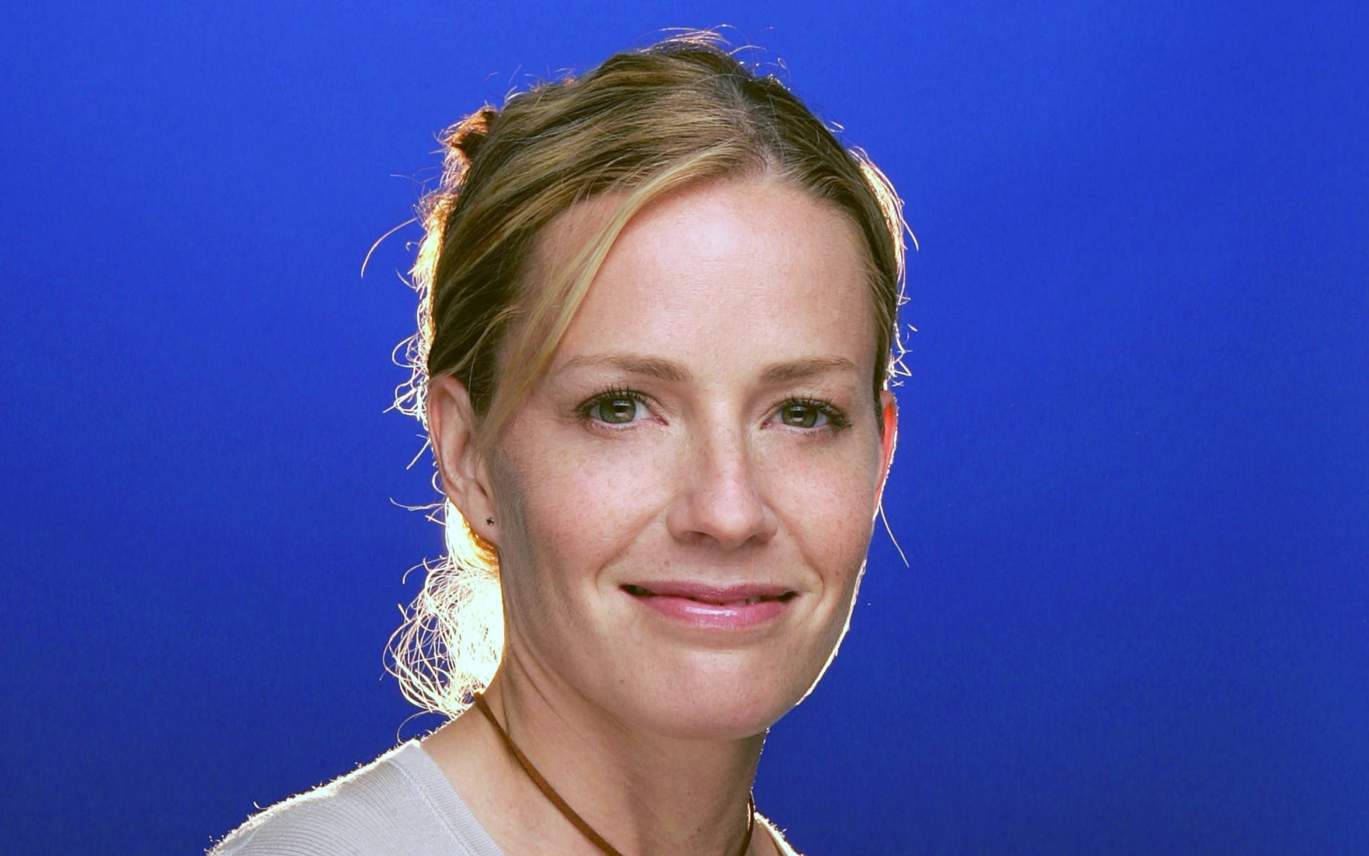 Close Up View Of Elisabeth Shue Smiling In Blue Background Background