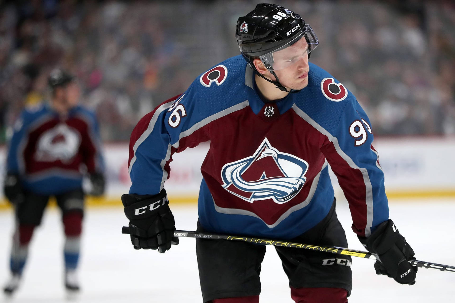 Close Up View Of Mikko Rantanen Looking To The Left While Holding Hockey Stick Background