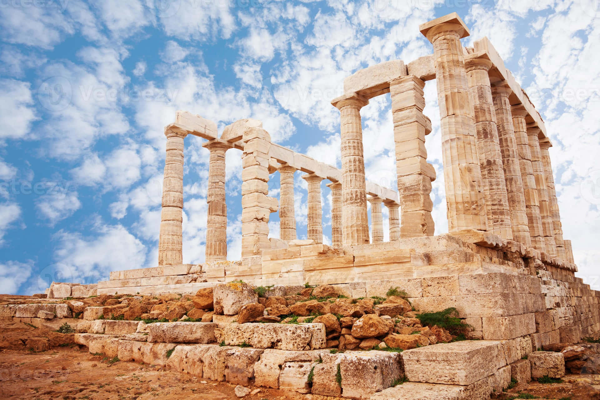 Cloudy Stone Pillars In Sounion Background