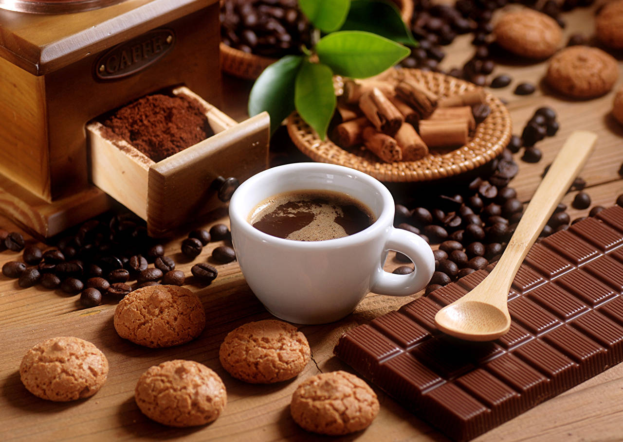 Coffee Cup Amidst Sweets And Beans Background