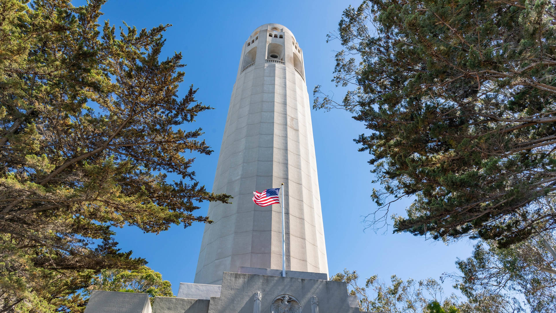 Coit Tower With A Proudly Waving American Flag Background