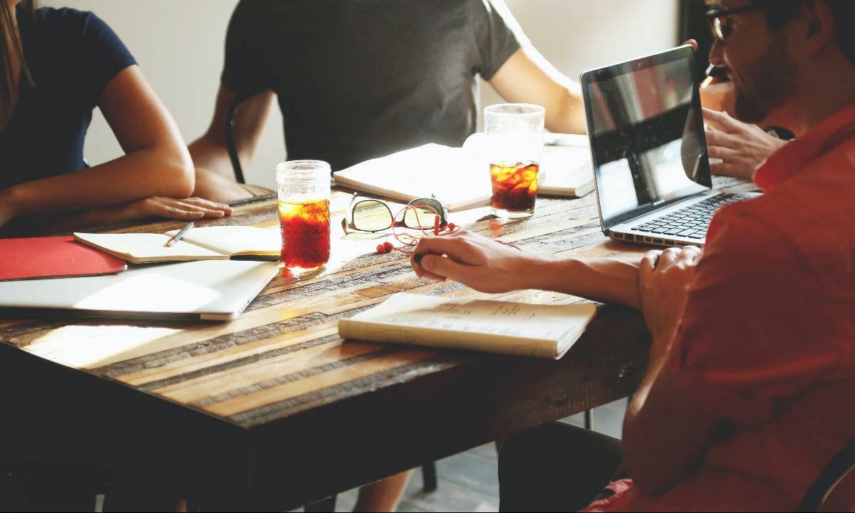 Collaborative Team Working Together At A Round Table Background