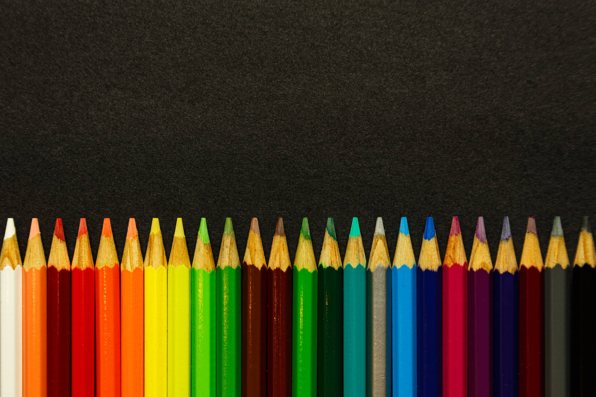Colored Sharp Pencils Against Black Surface Background