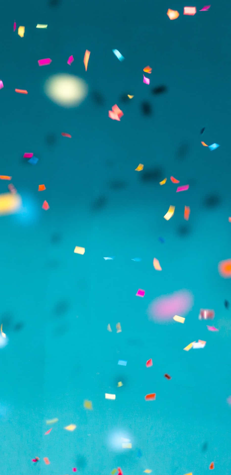 Colorful Confetti Falling Against Blue Background Background