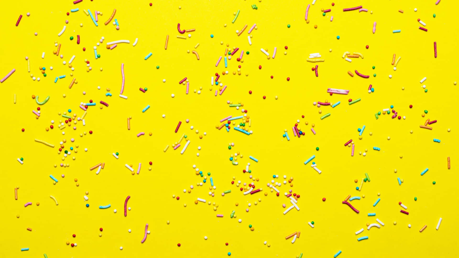 Colorful Sprinkleson Yellow Background Background