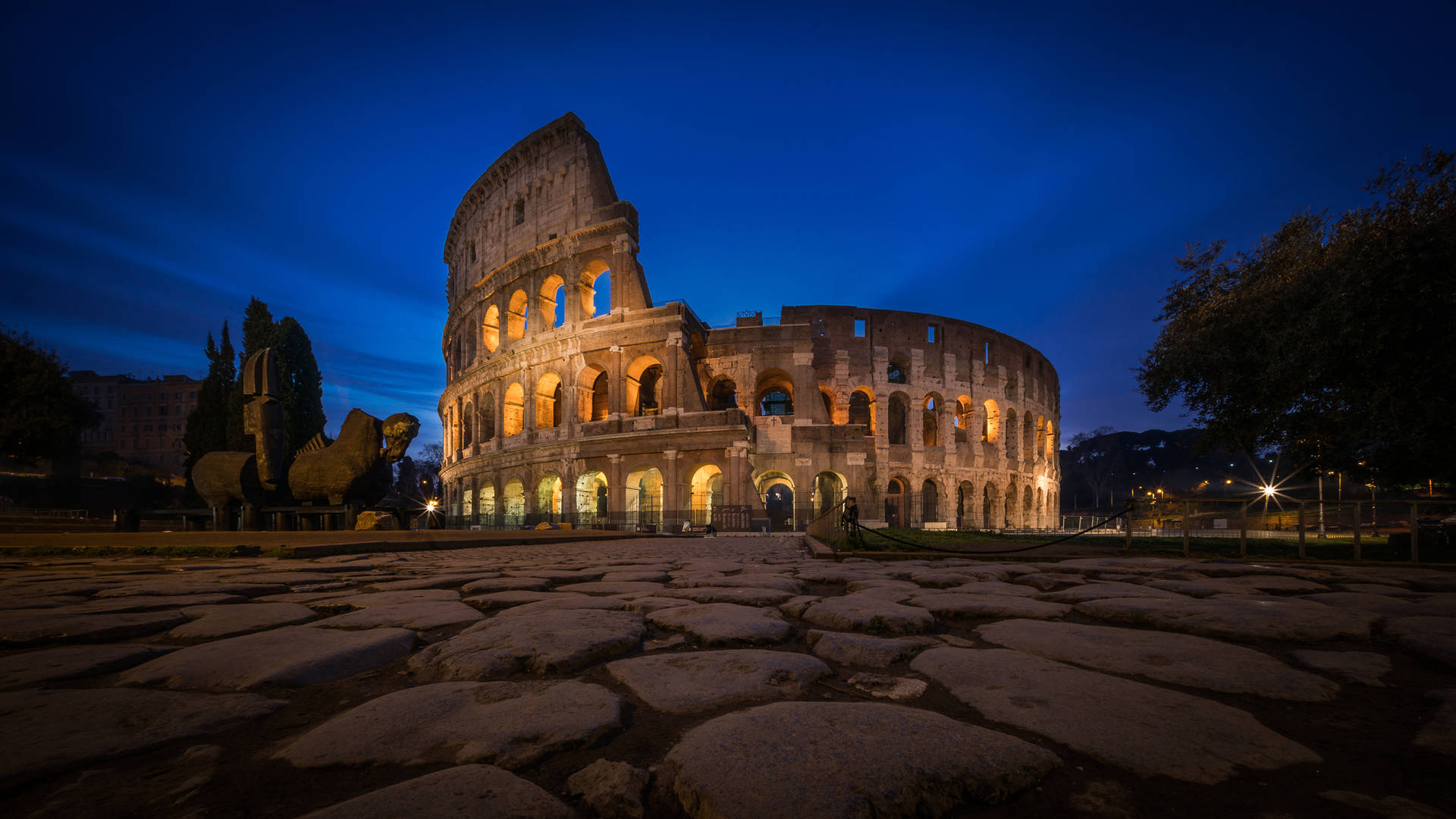 Colosseum In Rome Beneath The Cloudy Night Sky Background