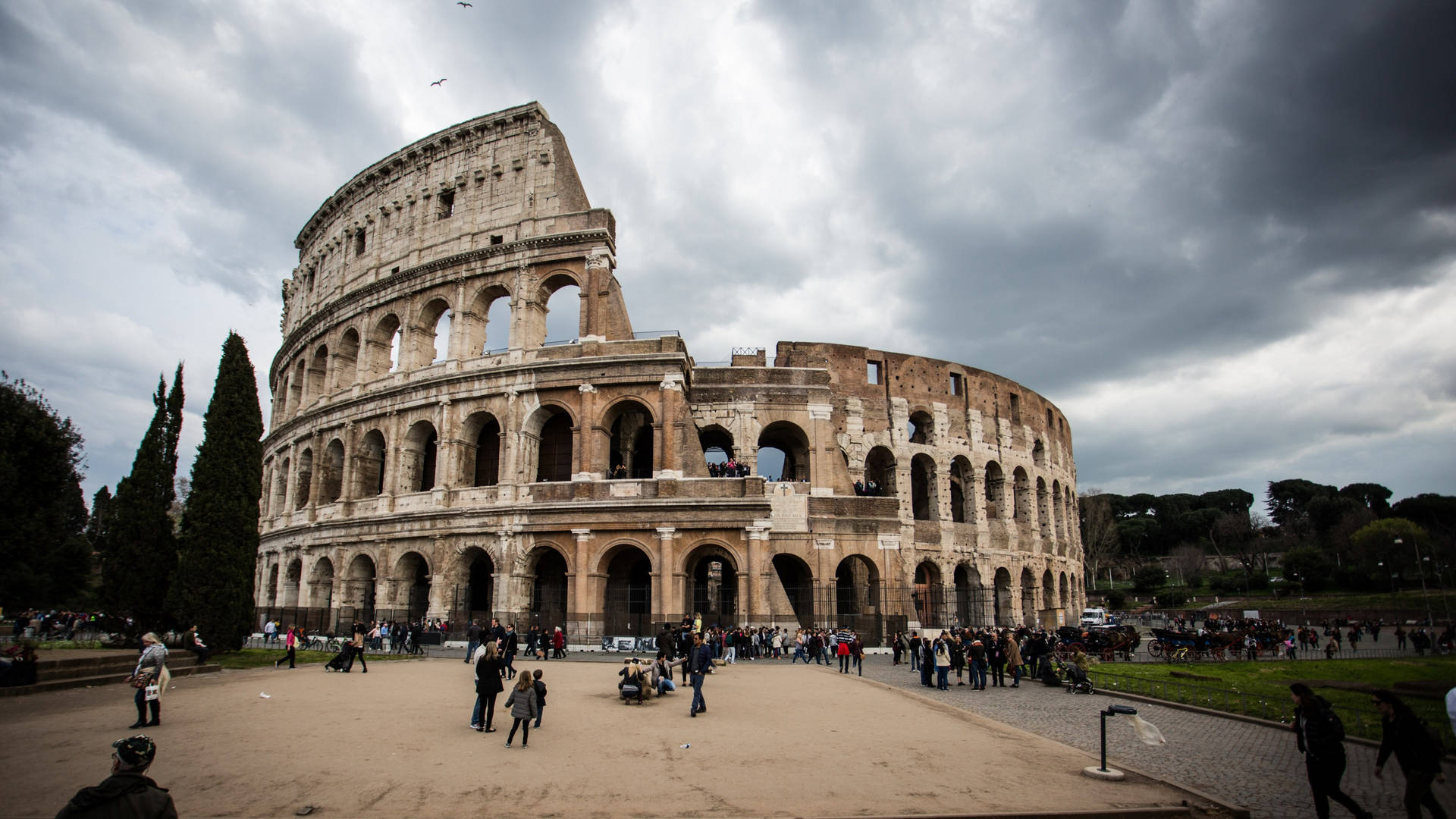 Colosseum In Rome Beneath The Cloudy Sky Background