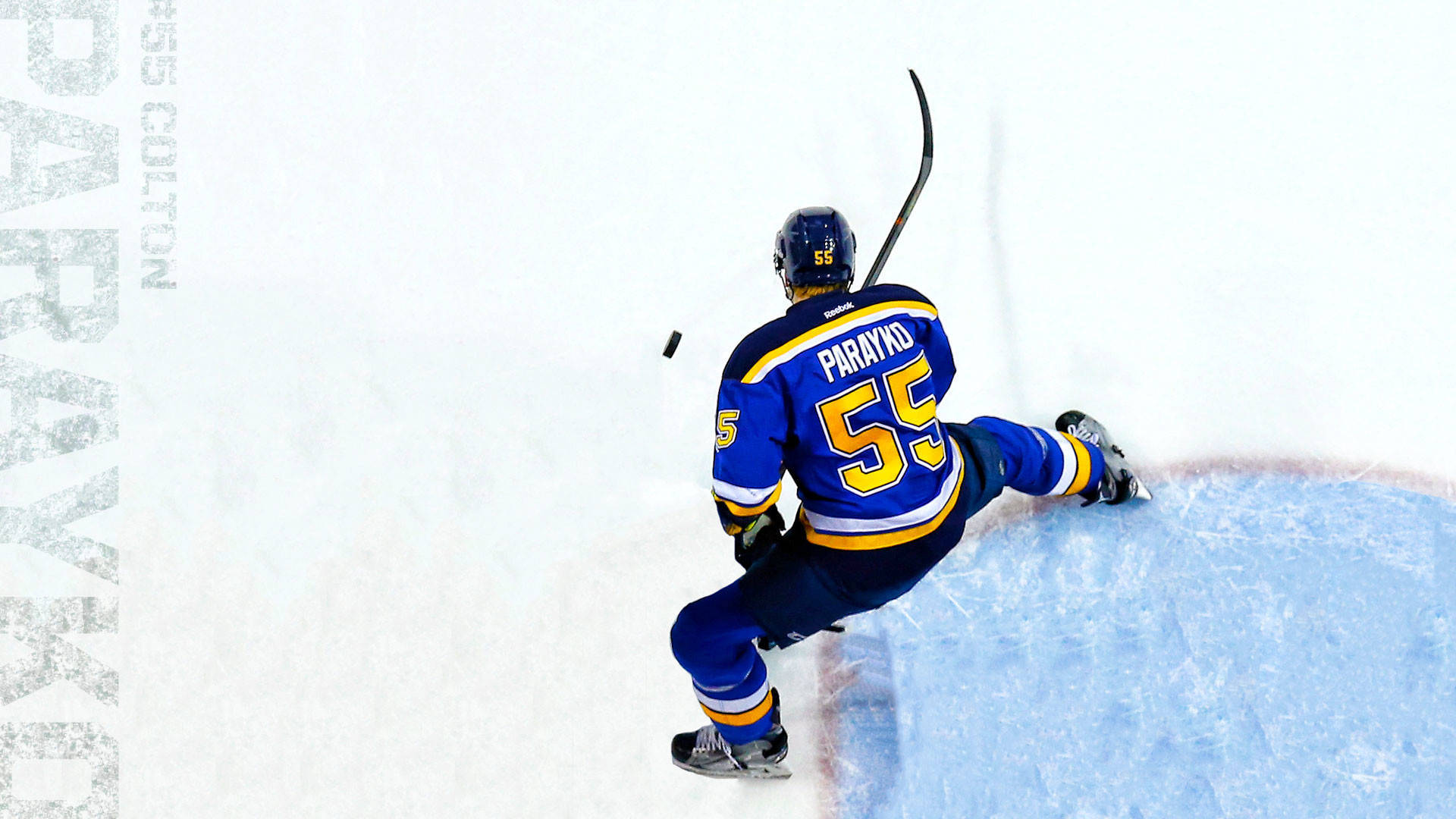 Colton Parayko Powerfully Striking The Puck In A Game Background