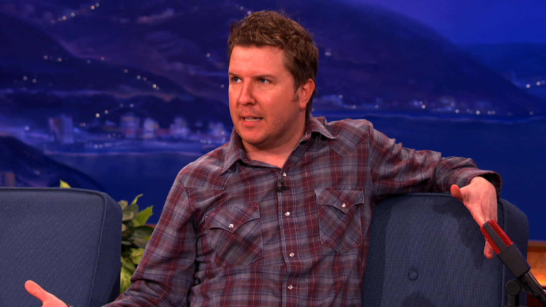 Comedian And Actor Nick Swardson Looks Cool And Confident On Stage. Background