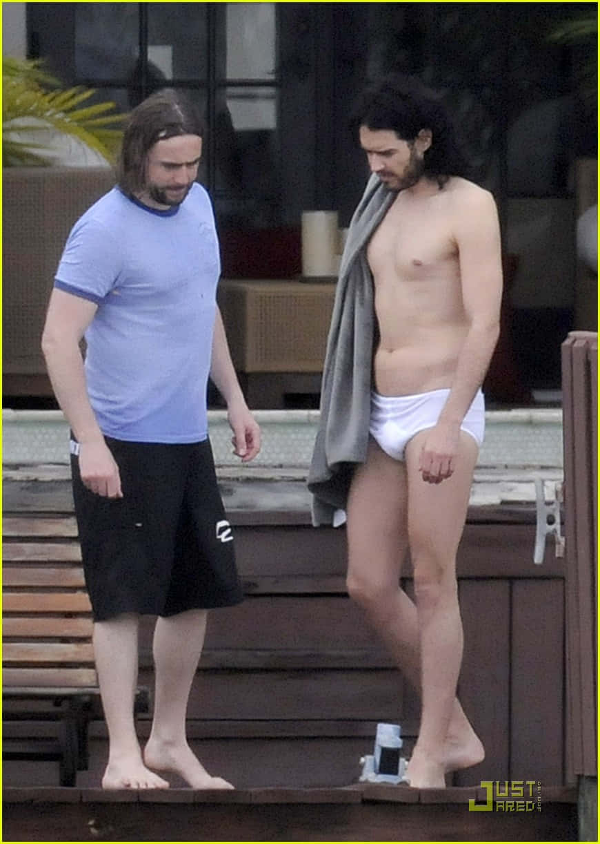 Comedian Russell Brand In An Amusing Pose Wearing Tighty Whities. Background