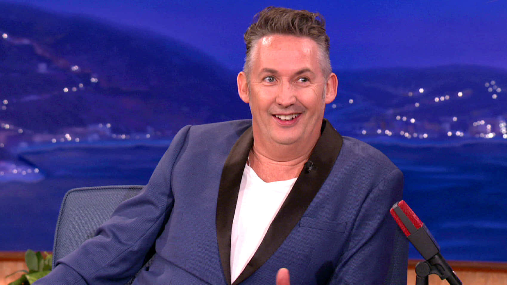 Comedianin Blue Blazer Talk Show Appearance Background
