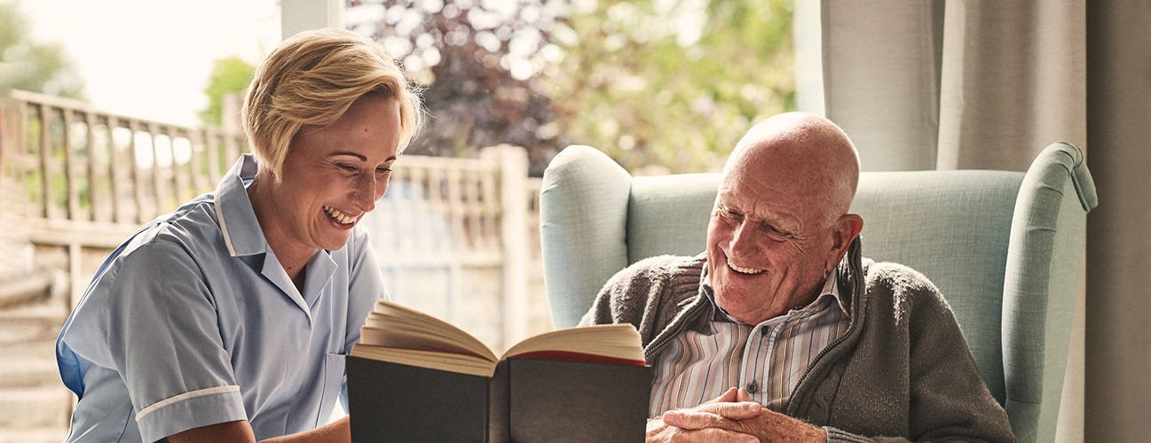 Compassionate Caretaker Assisting Elderly Patient Background