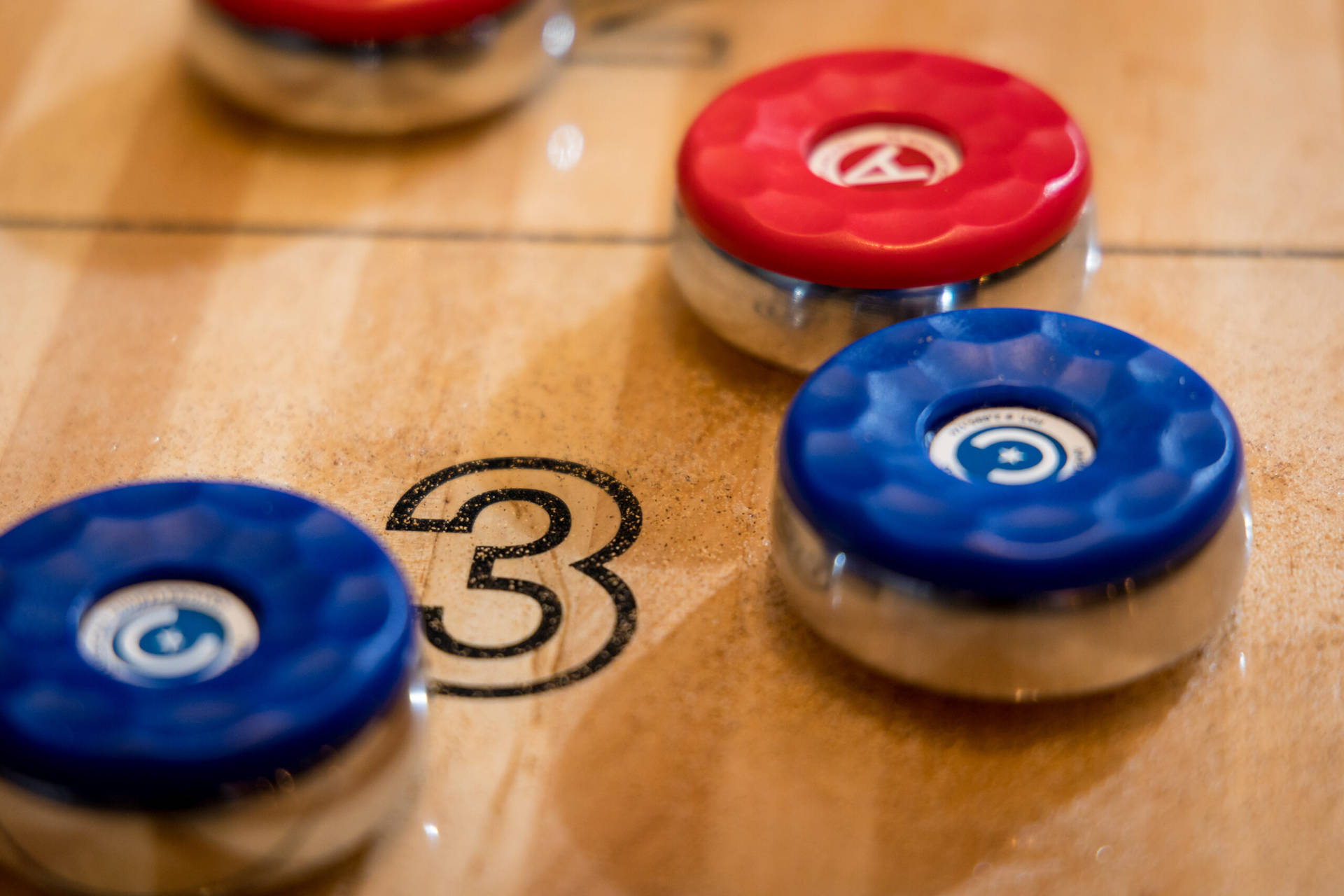 Competing In Shuffleboard - A Close-up Shot Of A Number Three Scoring Puck. Background