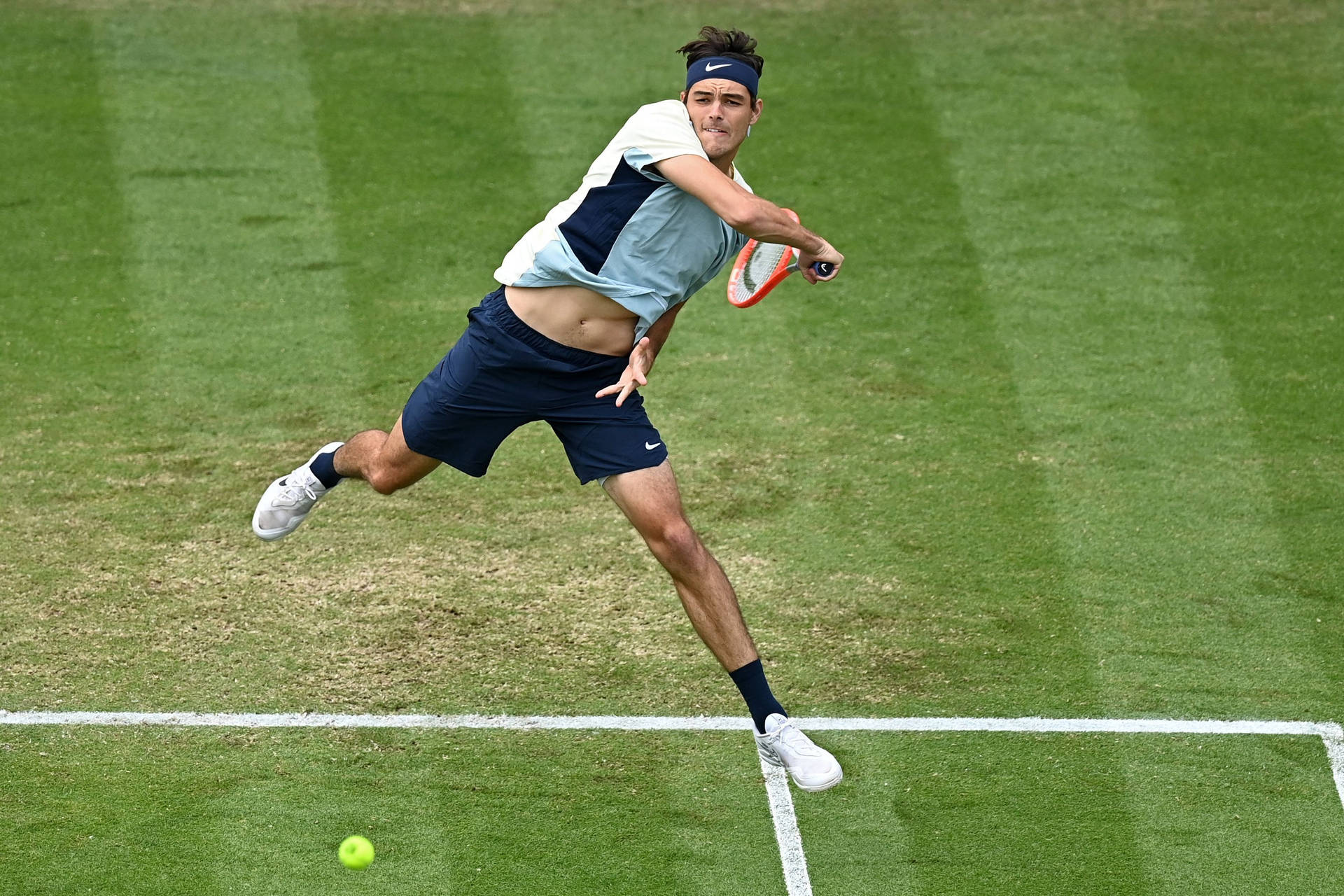 Concentrated Taylor Fritz Executing A Backhand Stroke Background