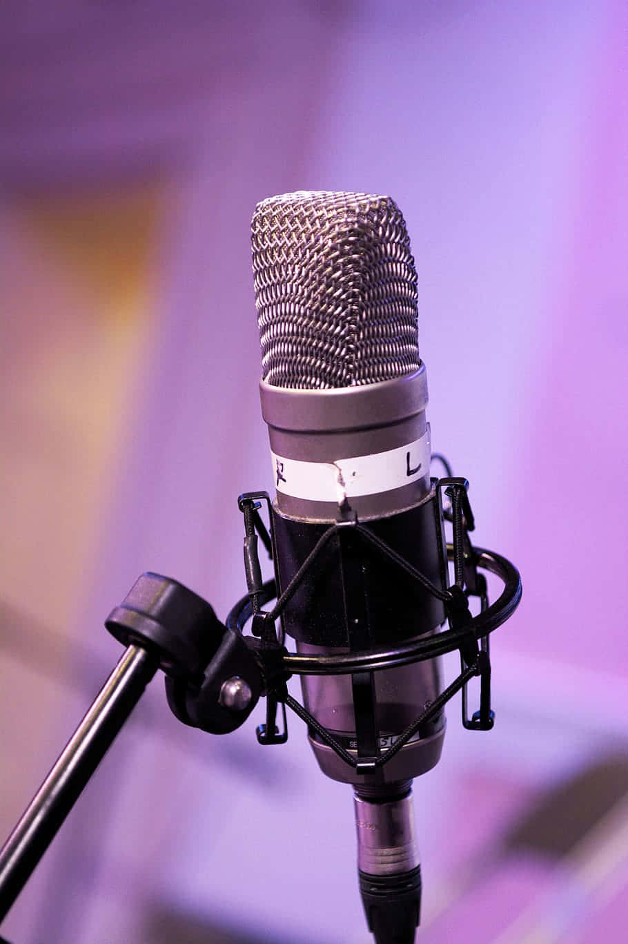 Condenser Microphone Against A Purple Backdrop Background